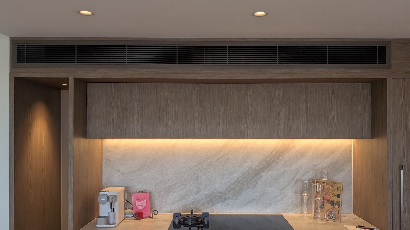 Technician working on installing an air conditioning vent in the ceiling.