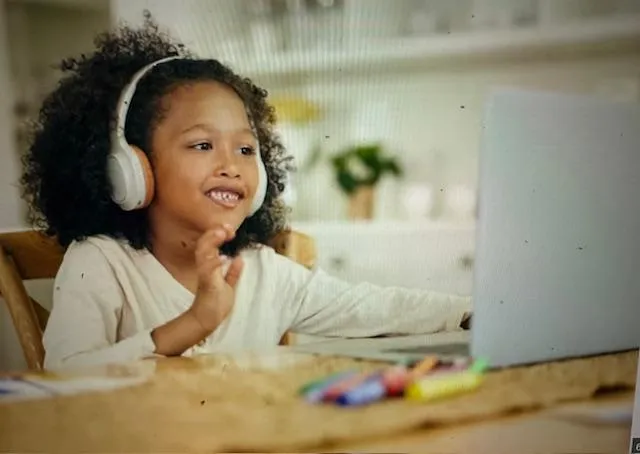 Child waves at laptop