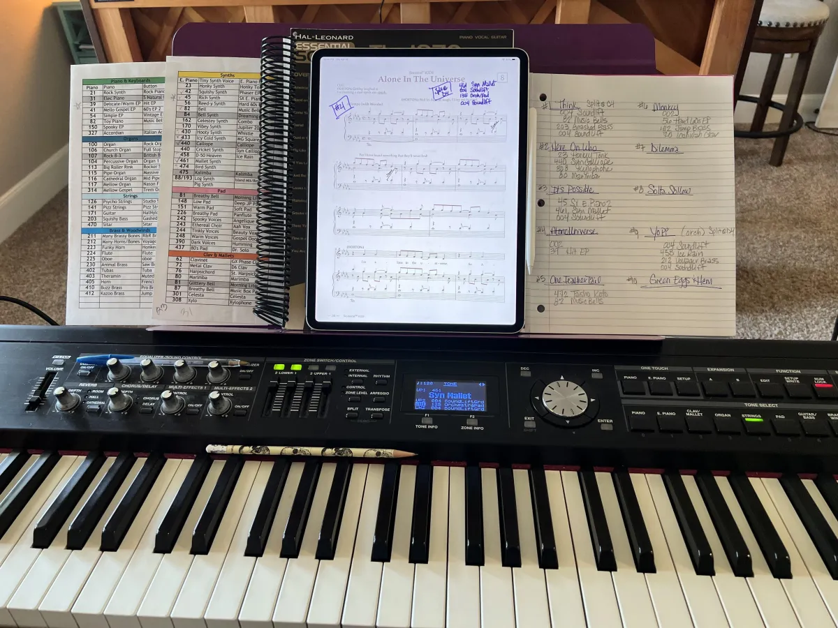 midge's electric piano with open music sheets and tablet