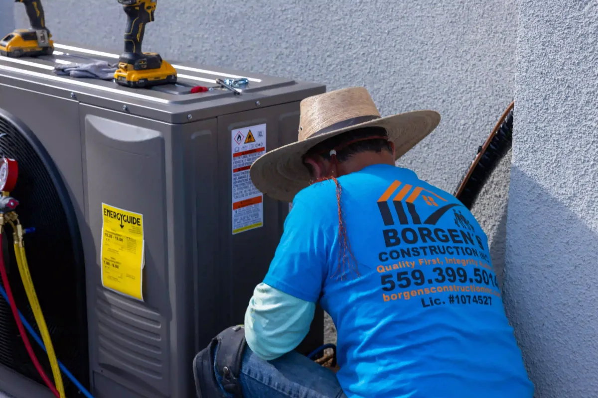 HVAC technician from Borgen’s Construction installing and servicing an outdoor air conditioning unit in Fresno, CA