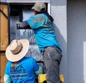 Professional HVAC technician working on the electrical connections of a newly installed slim-profile outdoor AC condenser unit.