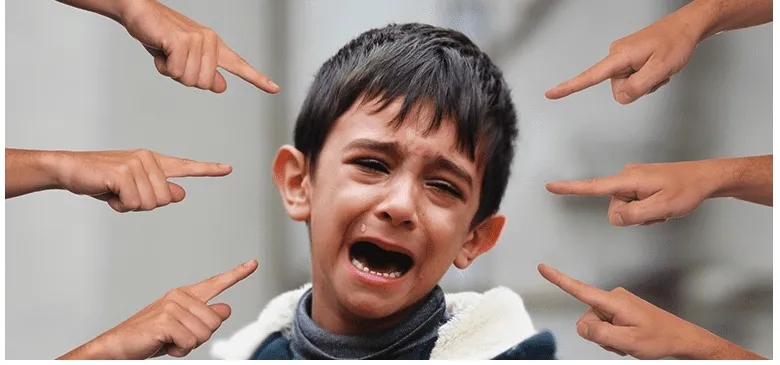 Jeune garçon en pleurs pointé du doigt par plusieurs mains, illustrant l'humiliation et l'anxiété.