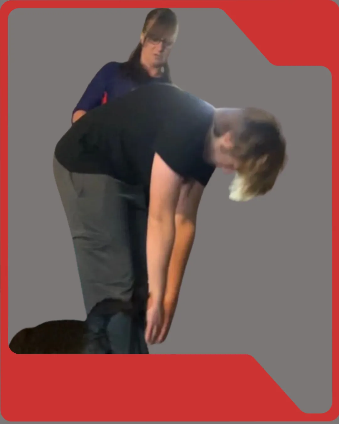 Strength coach using the movement screening app on a smartphone alongside an athlete on the training floor