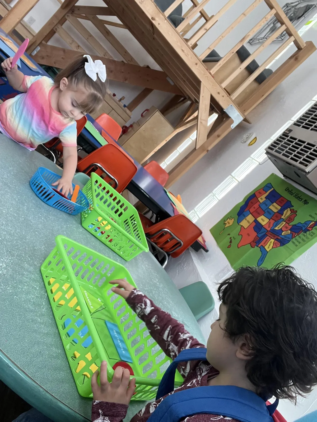 Girl stretches to the side while watching teacher on large screen TV