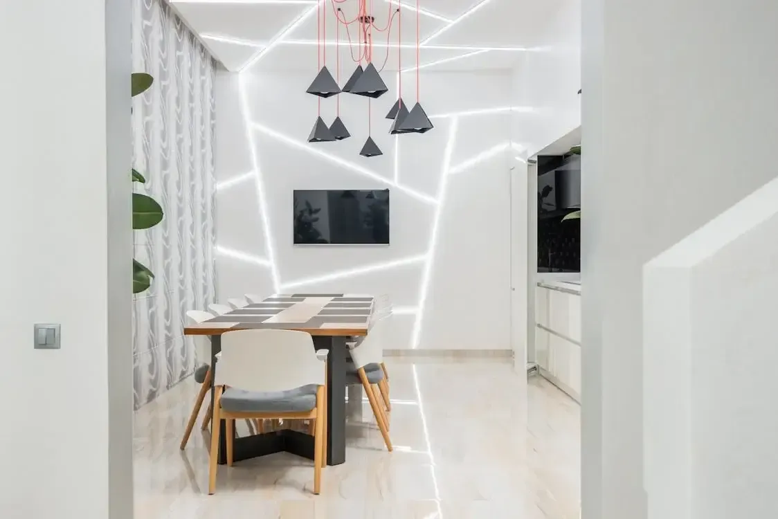 Modern dining room with artistic lighting, black pendant lamps, and a sleek table set.