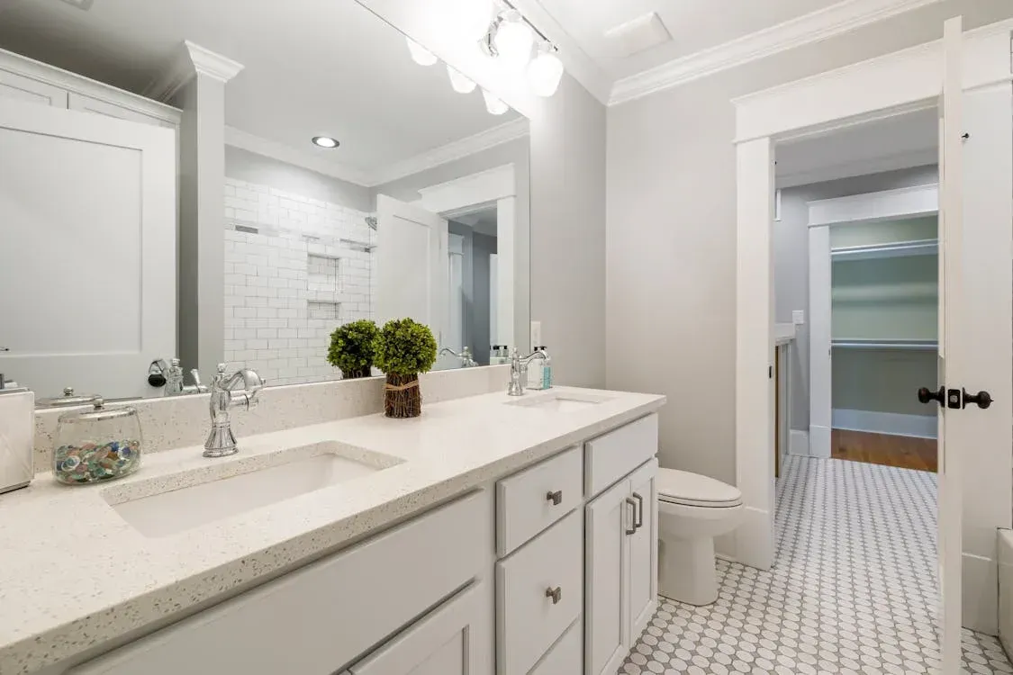 Modern bathroom with double vanity, subway tiles, and hexagonal floor tiles.