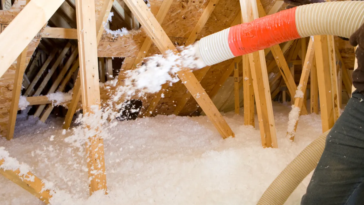 Photo of insulation being blown into an attic.