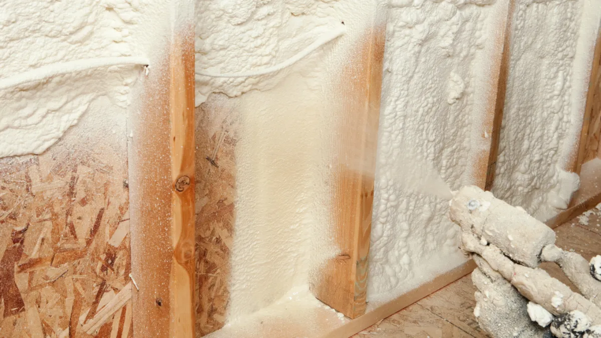 Photo of spray foam being sprayed inside a wall.