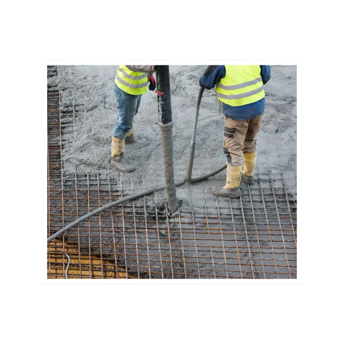 Worker pouring ready-mix concrete into formwork for a foundation, part of reliable ready-mix concrete services.