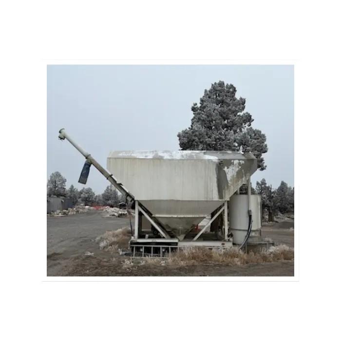 Volumetric ready-mix concrete truck mixing concrete fresh on-site for a commercial construction project.