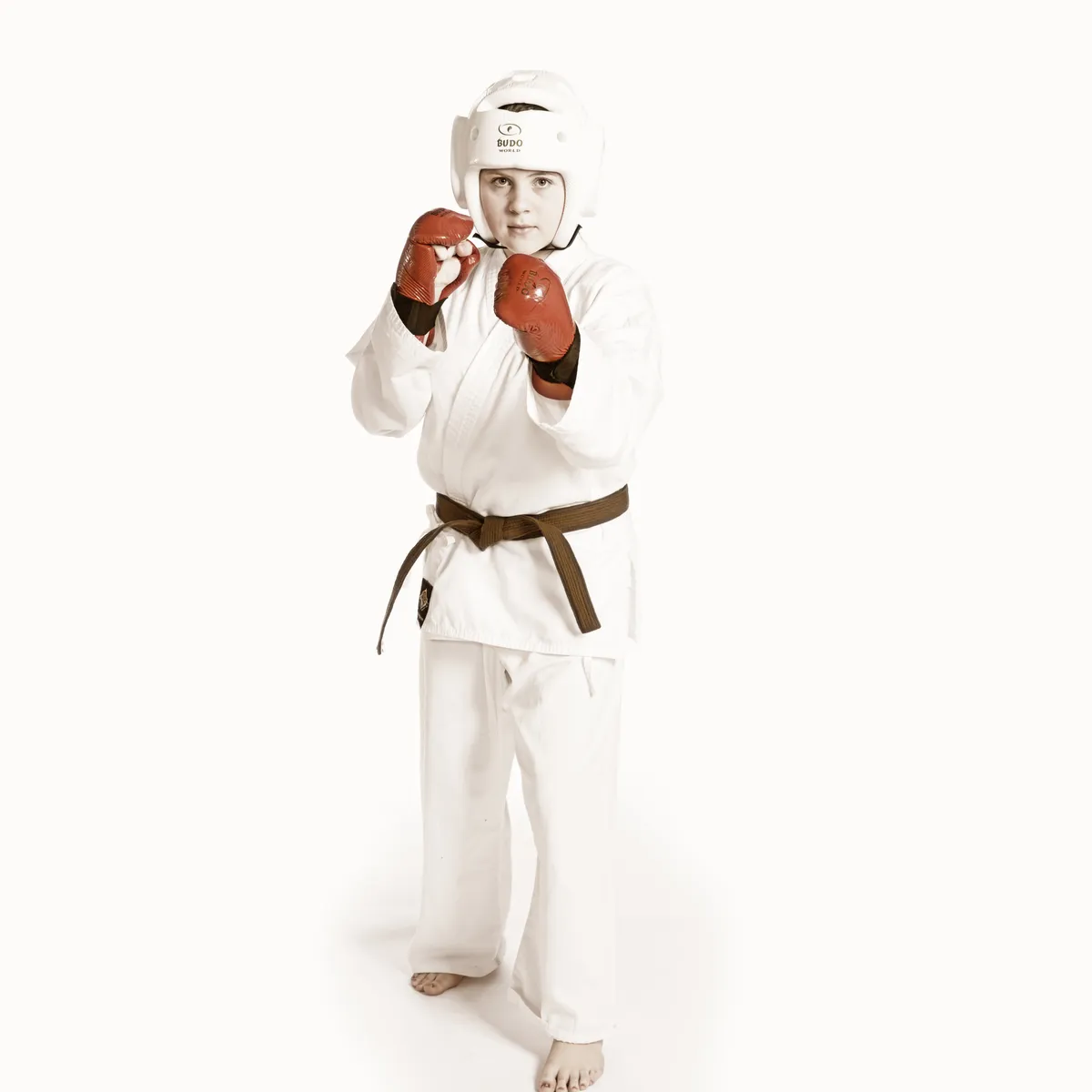 A young woman in a white gi demonstrating a self-defense technique against a young man in a black t-shirt