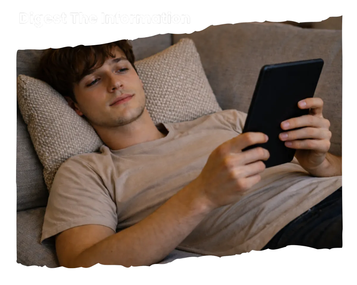 A boy lying down on the couch reading the ebook