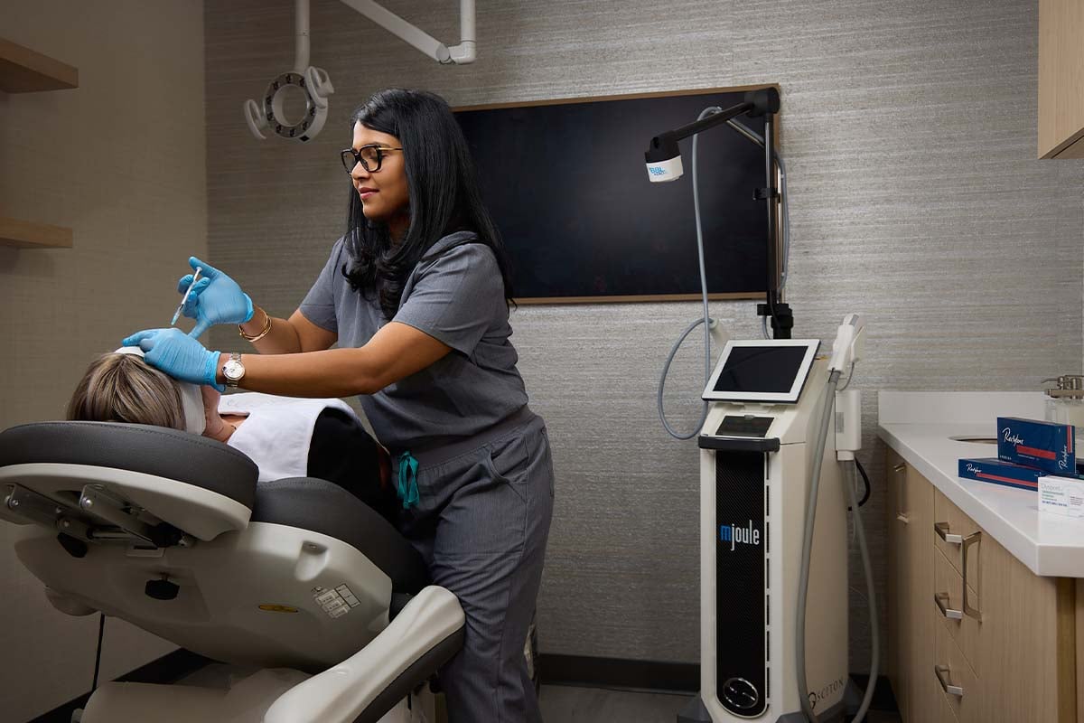 Woman in sauna holding ladle over bucket