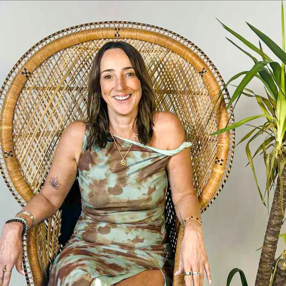 woman sat in wicker chair smiling