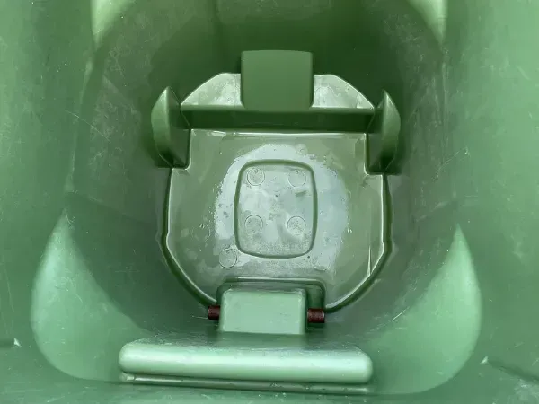 Close-up of a freshly cleaned green trash bin interior