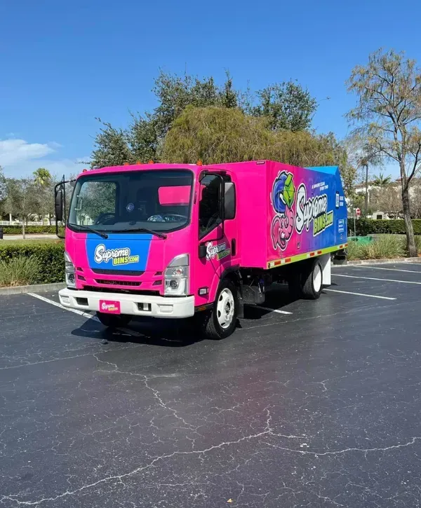 Supreme Bins branded truck parked on a sunny day in an empty parking lot