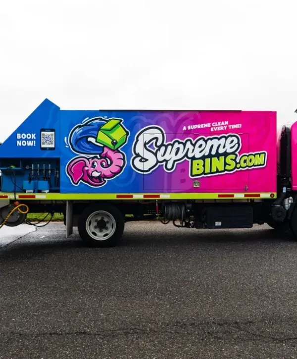 Supreme Bins colorful cleaning truck parked on the road, promoting bin cleaning services.