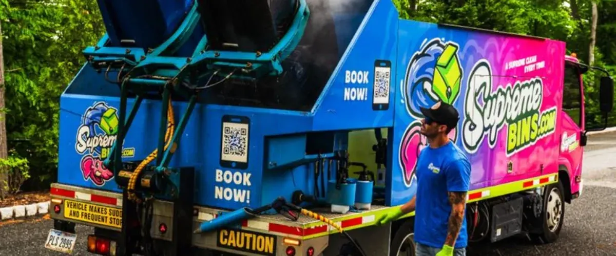 Supreme Bins truck performing trash bin cleaning service in a residential neighborhood.