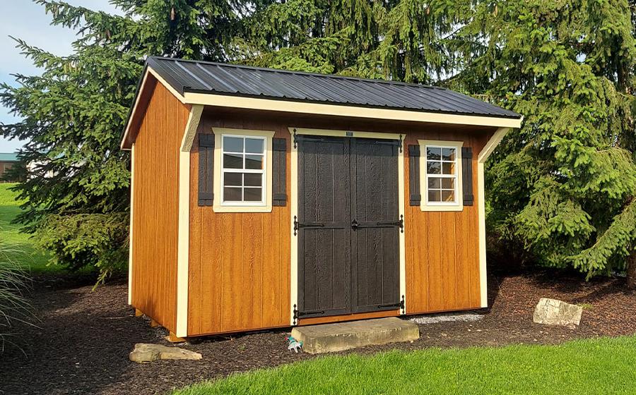 Custom wooden outdoor shed with black trim and double doors built in a San Antonio backyard