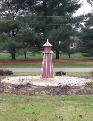Purple lighthouse surrounded by a stone garden in the front yard of Paradisus Church of God on Ridge Road.