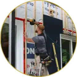 Our roofer securing exterior panels with a drill during installation work.