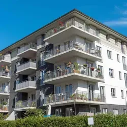 Apartment building with multi-unit residential roofing system and balconies in urban area