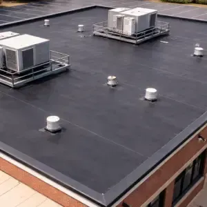 Commercial building with EPDM rubber roofing, rooftop units, and vent stacks on flat roof