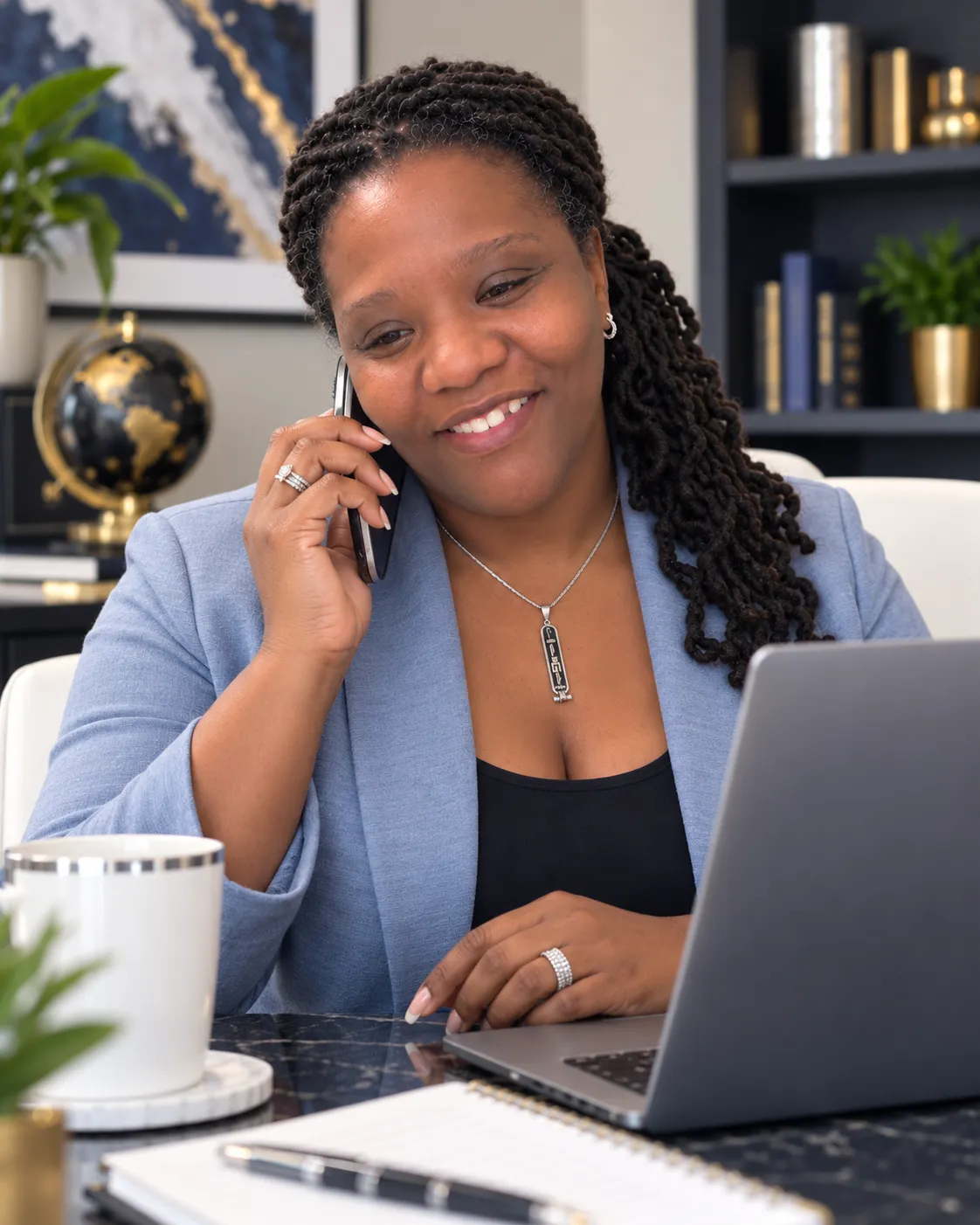 Chappelle Roe speaking with a client by phone while working on a laptop in her office.
