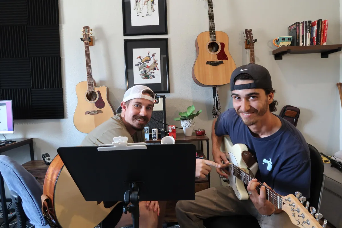 shallow focus photography of brown acoustic guitar