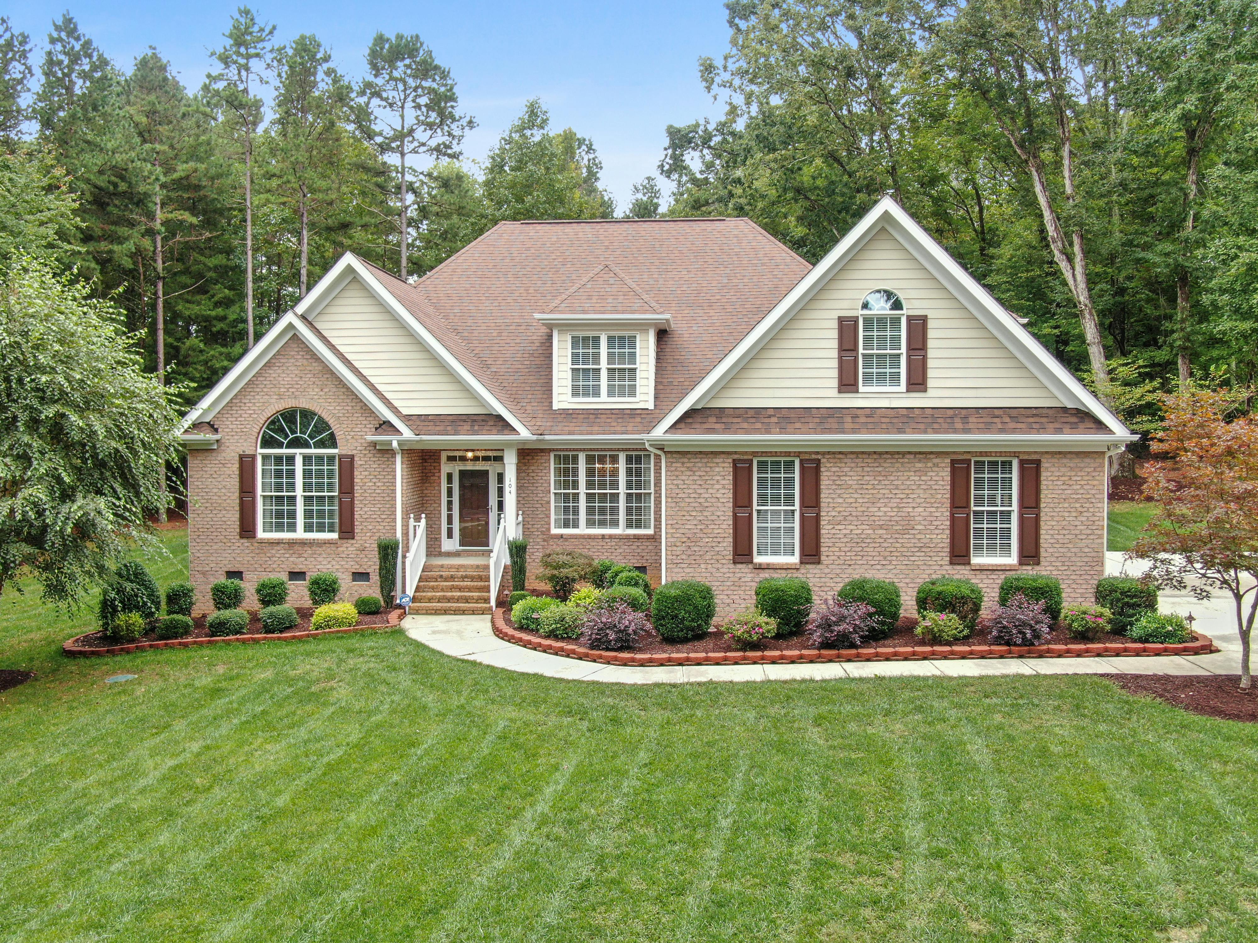 Brick home with manicured landscaping and wooded lot in Bloomington Indiana
