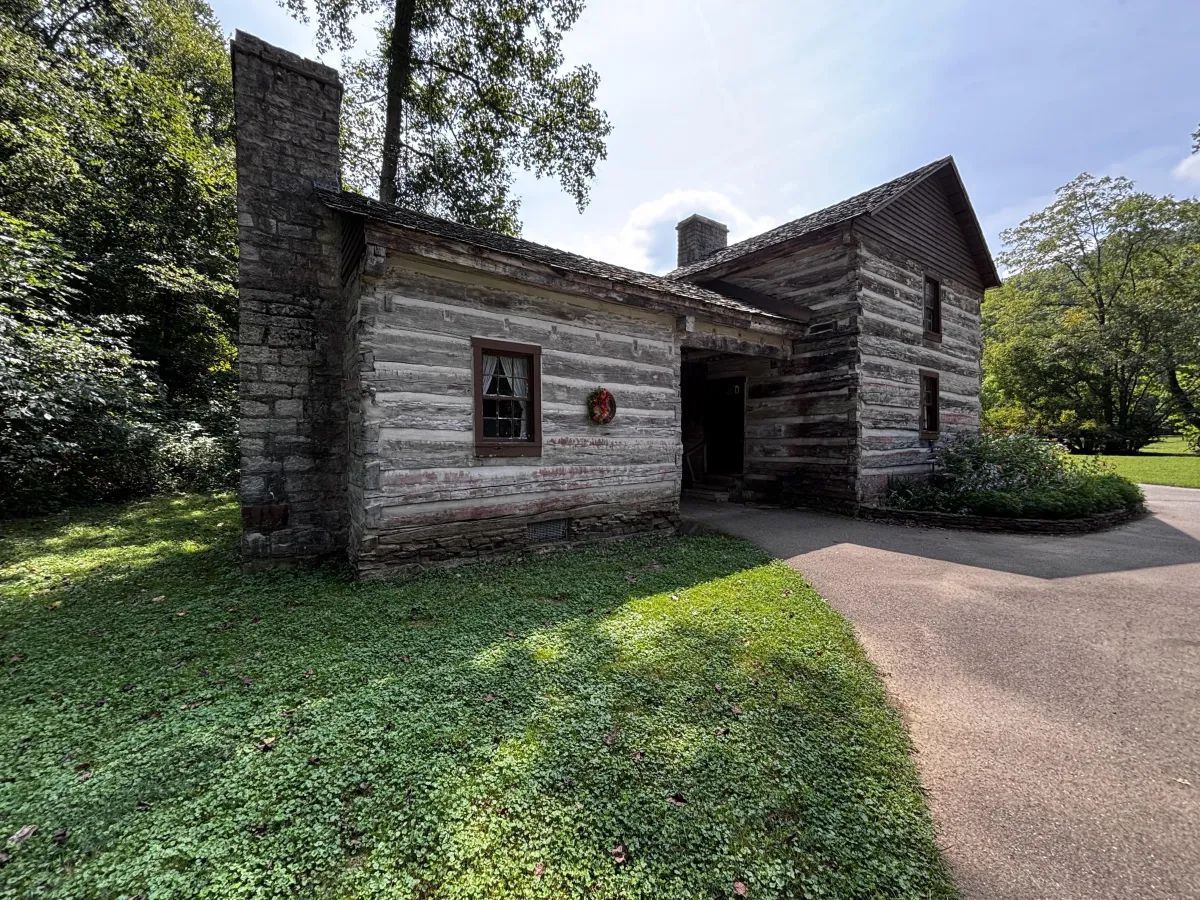 Restored log weaver's cottage with stone chimney at Pioneer Village, Spring Mill State Park, Mitchell, Indiana