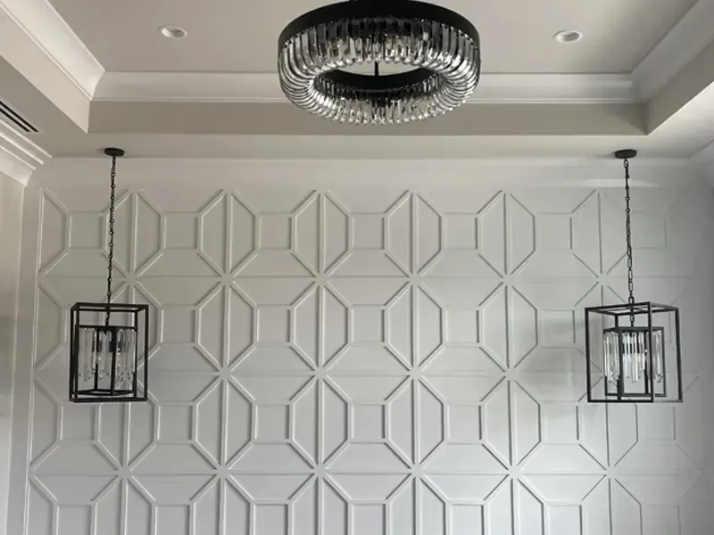 Luxury custom geometric accent wall paneling and intricate crown molding professionally installed by Brothers Home Group in a Naples residence