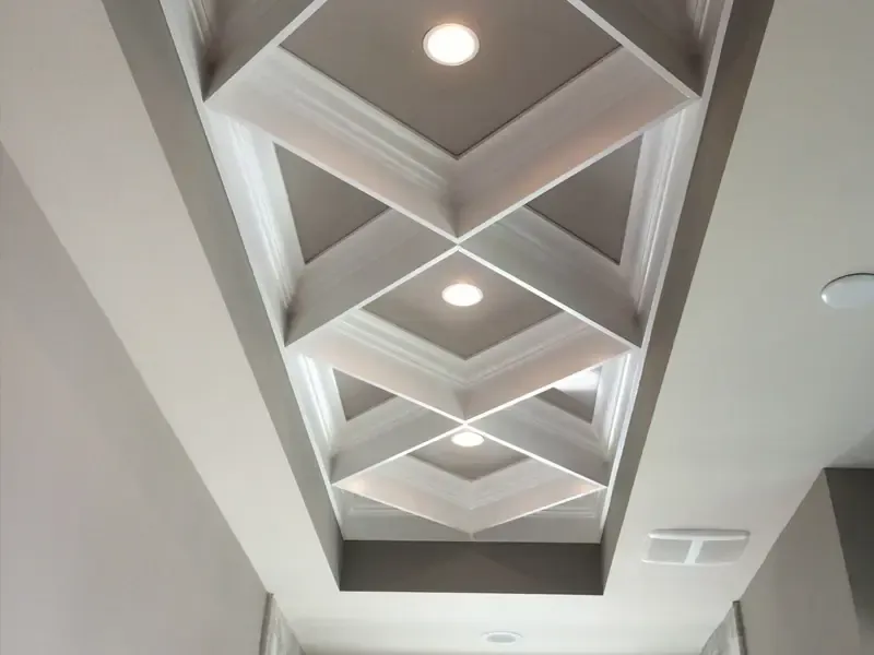 Masterful precision: Intricate close-up of custom crown molding and detailed ceiling trim professionally installed by Brothers Home Group in a luxury Naples home