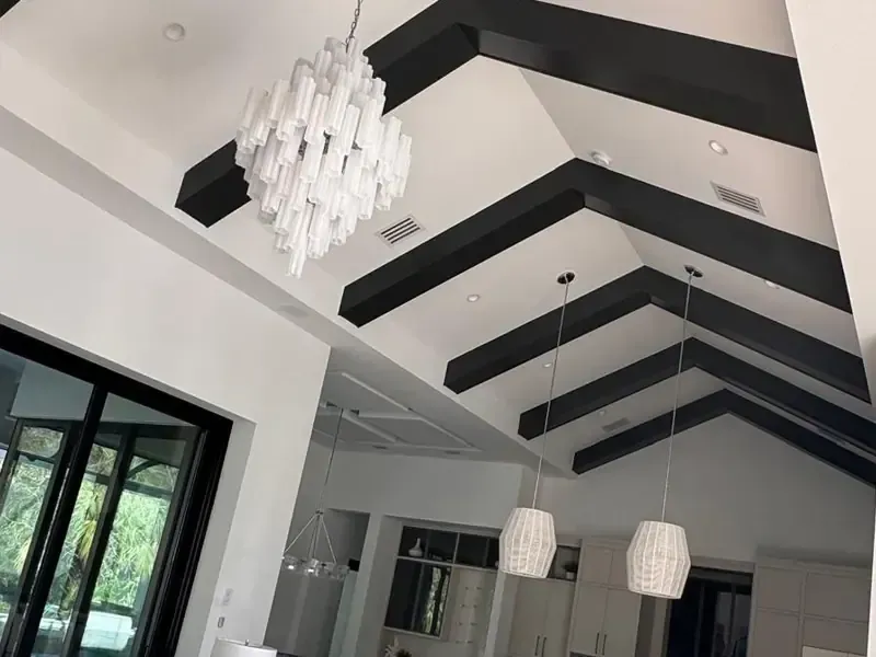Stunning vaulted ceiling featuring white shiplap panels and thick dark wood accent beams, professionally installed for a modern farmhouse look.