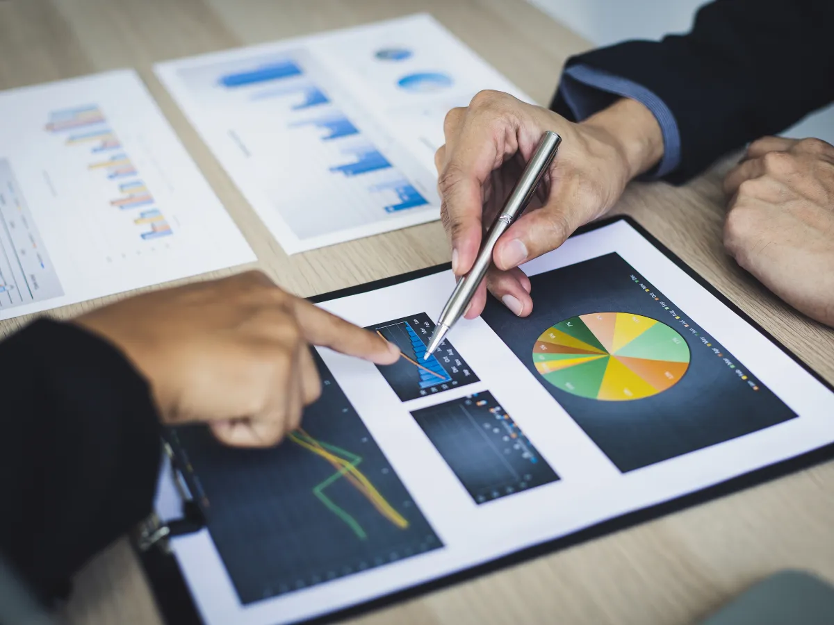 Hands analyzing M&A risk assessment document with charts, emphasizing strategic planning.