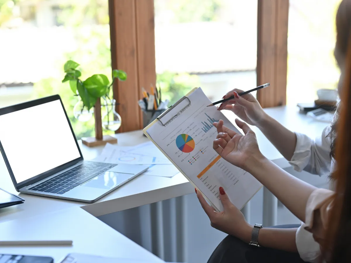 Two women reviewing HR charts and data analysis during virtual M&A training session.