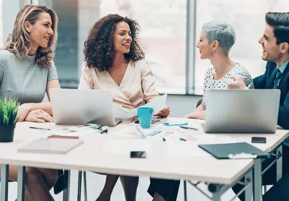 Diverse HR and M&A professionals networking and sharing insights at collaborative work session, building relationships that drive successful merger outcomes
