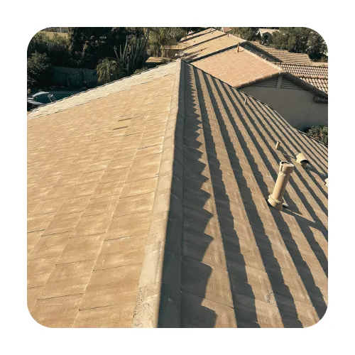 Ariel view of a tan flat tile roof ridge line in a Gilbert AZ neighborhood, highlighting durable desert roofing materials.