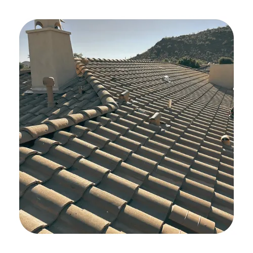 Residential tile roof repair in Gilbert showing multiple roof vents, a chimney, and tan curved clay-style concrete tiles.