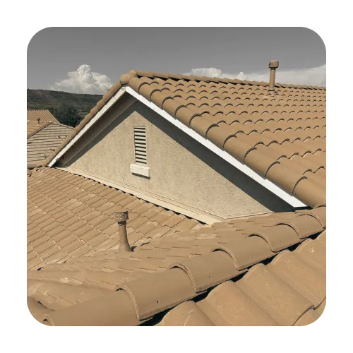 Concrete tile roof installation on a residential home in Gilbert, Arizona featuring tan curved S-tiles and attic gable vent.