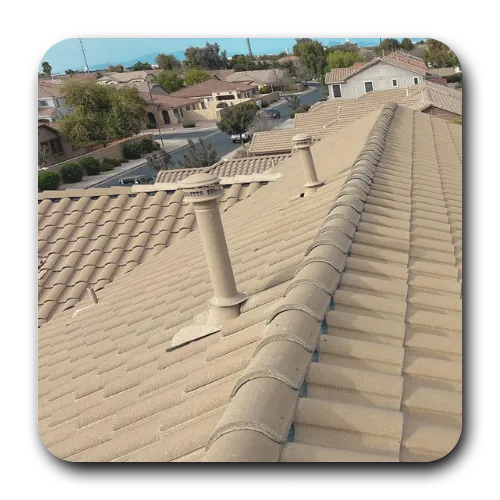 Maintenance of roof plumbing boots and exhaust vents on a tan tile roof in a San Tan Valley residential community.