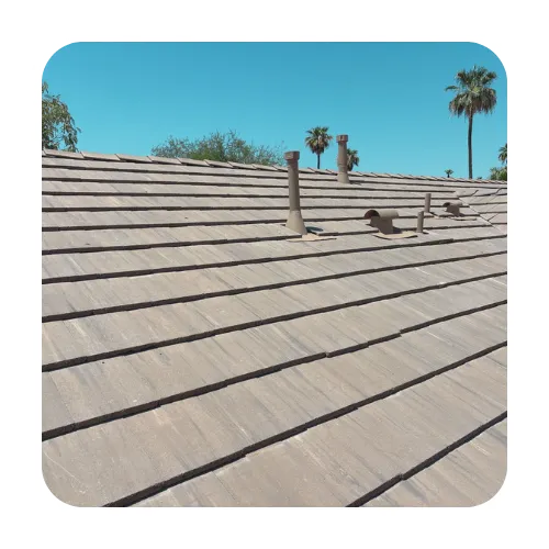 Professional tile roof inspection in Chandler, AZ, featuring gray flat concrete tiles and properly flashed plumbing vents.