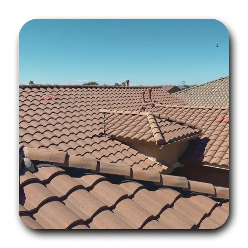 Terracotta S-tile roof installation in Chandler, Arizona, showcasing decorative dormer peaks and ridge cap precision.