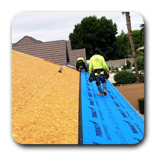 Skilled roofers queen creek arizona installing blue synthetic underlayment as part of a comprehensive roof replacement queen creek project.