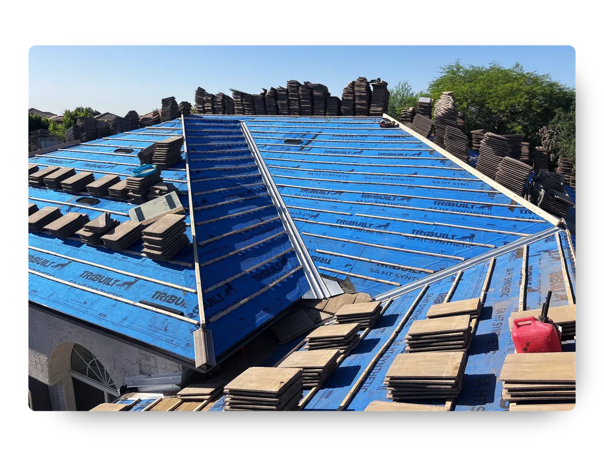 Phoenix roofing company replacing tile roof with blue synthetic underlayment and stacked roof tiles