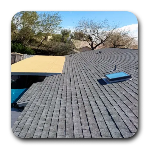 Newly completed grey architectural shingle roofing Tempe AZ installation featuring a rooftop skylight.