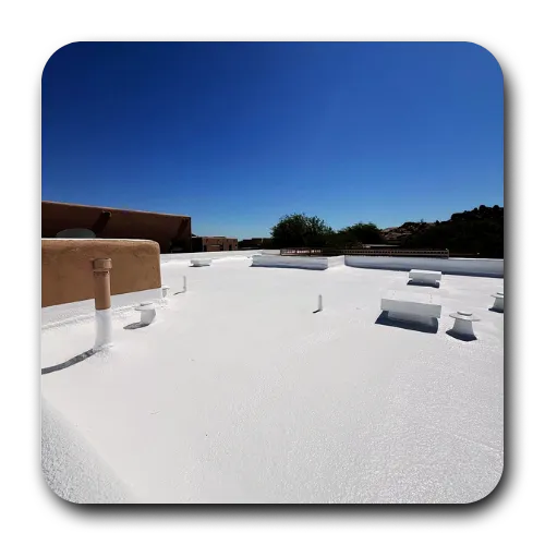 Freshly coated white cool roofing system on a flat roofing Tempe AZ commercial structure under a clear sky.