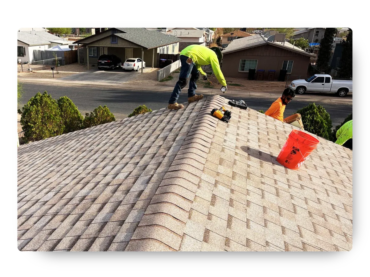 Contractors actively working on a shingle roofing project provided by a top-rated roofing company near me.