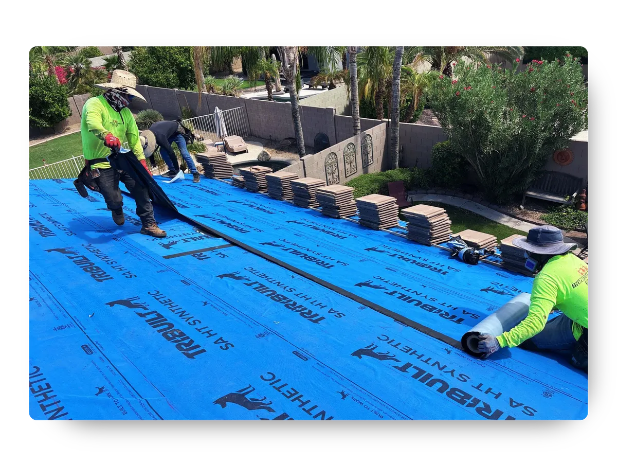 Roofing contractors laying protective blue synthetic underlayment for a roof replacement Apache Junction AZ