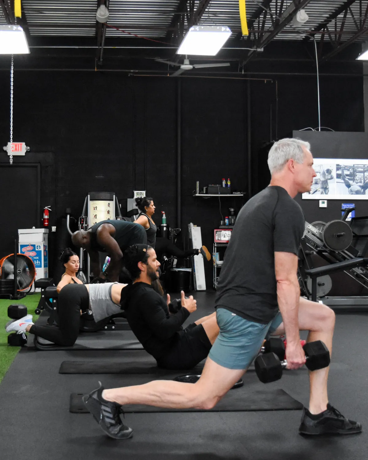Group of four clients training with a personal trainer during a semi-private session at AFIT Personal Training Studio in Coral Springs.